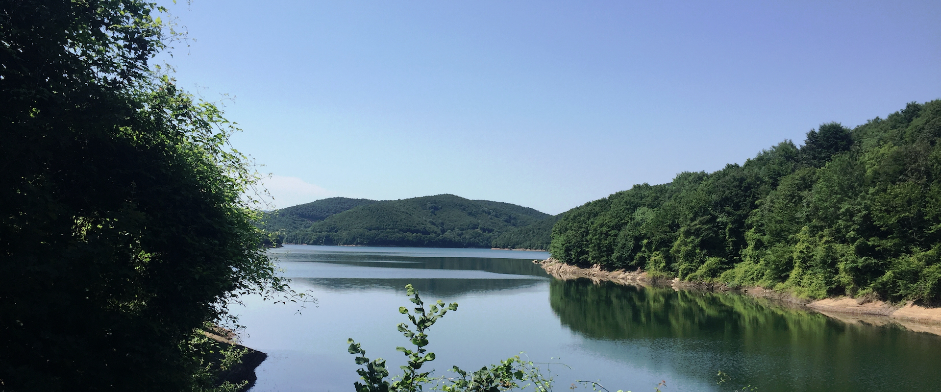 Wooded hills around the calm water of Darlık Dam Lake